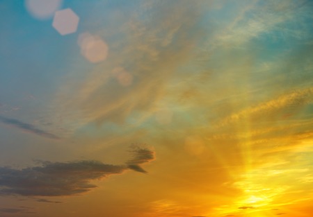setting sun paints the evening sky in shades of yellowの写真素材