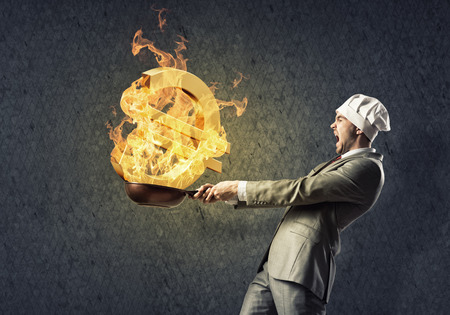 Young man in business suit and cook hat holding panの写真素材