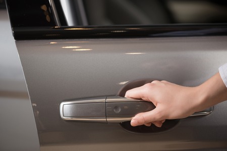 Close up of human female hand opening car doorの写真素材