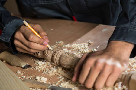 Close up carpenter\'s hands that work with cutterの写真素材