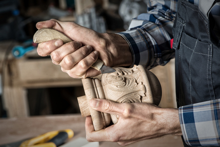 Close up carpenter\'s hands that work with cutterの写真素材