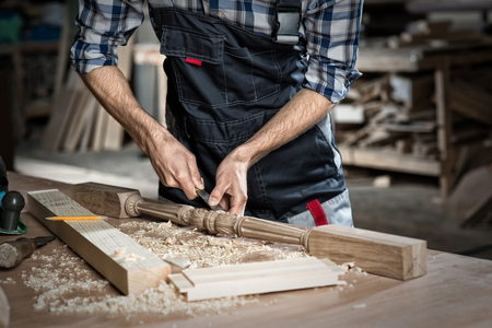 Close up carpenter\'s hands that work with cutterの写真素材