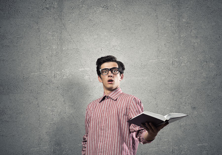 Young funny man in casual with book in handの写真素材
