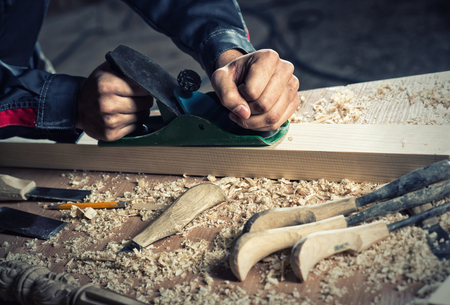 Close up of carpenter\'s hands working with the jointerの写真素材