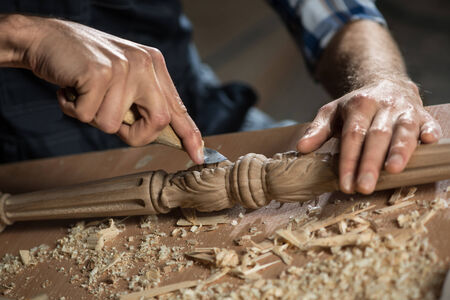 Close up carpenter\'s hands that work with cutter