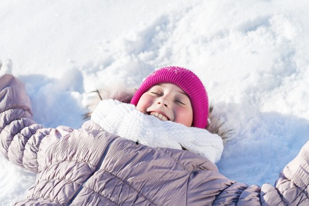 Top view of cute girl lying on snow