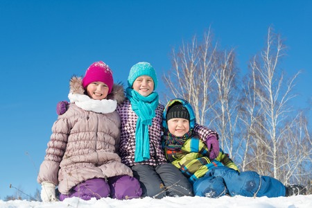 Three happy kids having fun in winter parkの写真素材