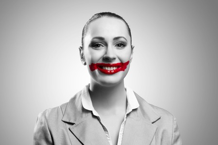 Conceptual black and white image of a young woman with vivid red mouthの写真素材