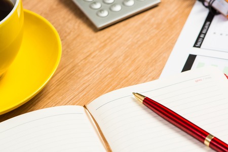 image of a cup of coffee, calculator, notepad and pen. business still lifeの写真素材