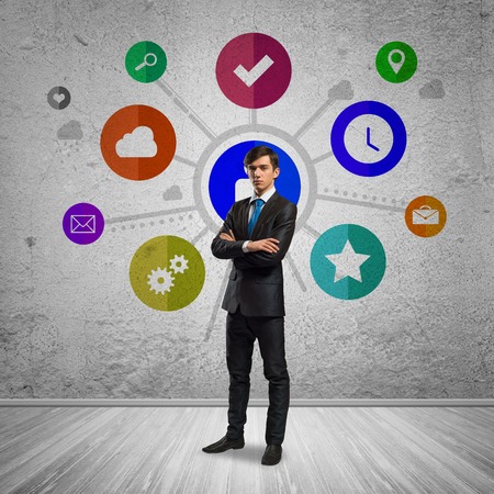 Thoughtful businessman and color application icons at backgroundの写真素材