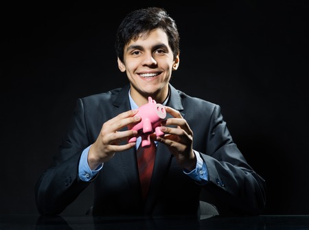 Businessman holding pink piggy bank in handsの写真素材