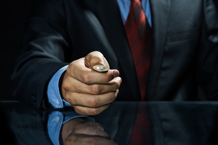 Close up of businessman holding coin in handの写真素材
