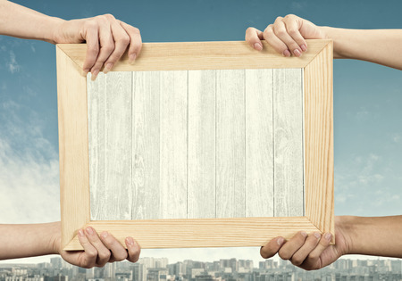 Close up of human hands holding wooden frame