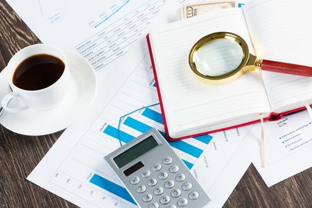 Close of business workplace with financial reports and office stuffの写真素材