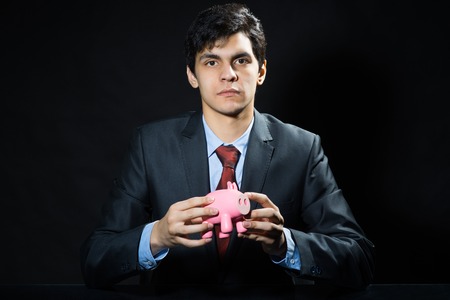 Businessman holding pink piggy bank in handsの写真素材
