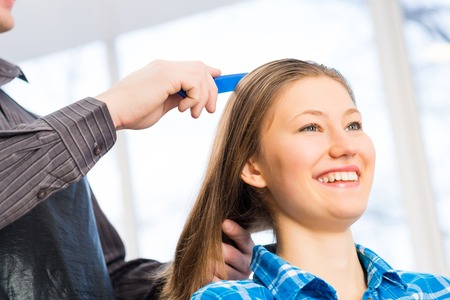 male hairdresser puts woman\'s hair in a hairdressing salonの写真素材