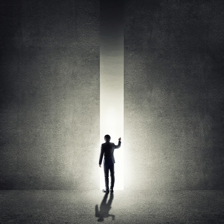 Rear view of businessman standing in light of wayの写真素材