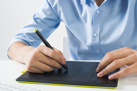 Young graphic designer sitting at desk and workingの写真素材