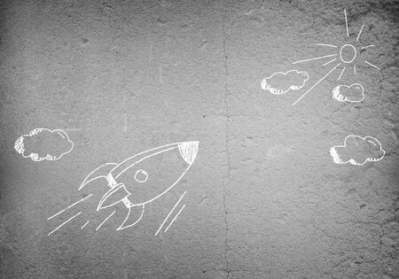 Background image with flying drawn rocket on cement wallの写真素材