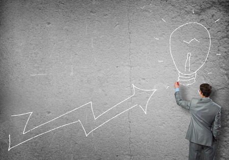 Rear view of businessman drawing increasing graphの写真素材