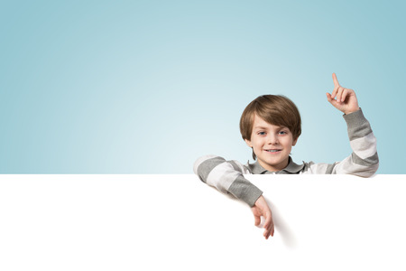 Cute boy of school age with blank advertising boardの写真素材
