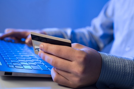 Close up of man using credit card to pay online