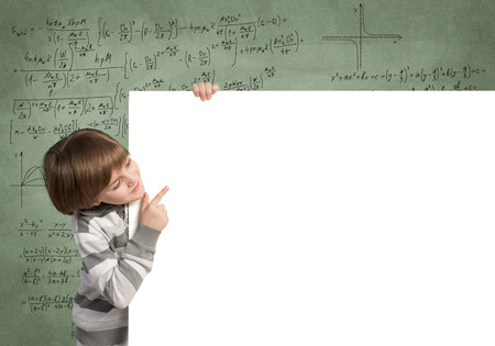 Cute boy looking from behind blank advertising boardの写真素材