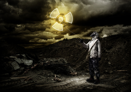Man in respirator with radioactivity balloon in handsの写真素材