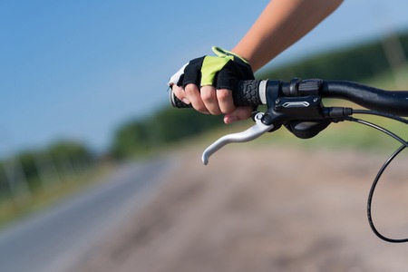 Unrecognizable young woman in shorts riding bicycle outdoorsの写真素材