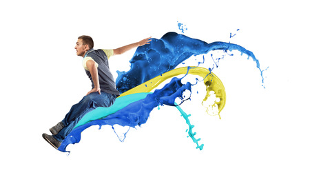 Modern styled dancer jumping over colorful paint splashesの写真素材