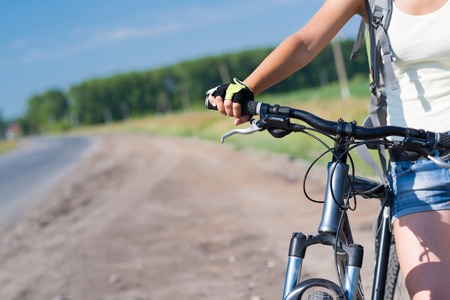 Unrecognizable young woman in shorts riding bicycle outdoorsの写真素材