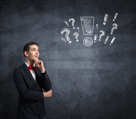 Young thoughtful man and sketches on wallの写真素材