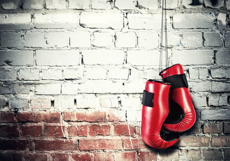 Boxing gloves hanging nailed to wall as concept of retirementの写真素材