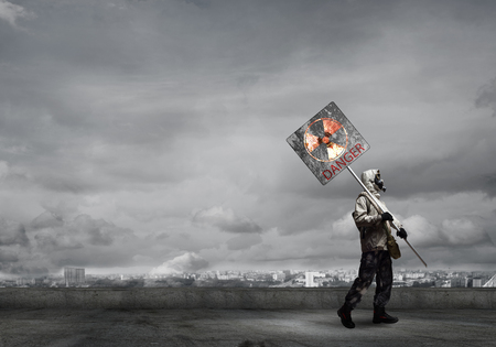 Stalker in gas mask with precaution danger signの写真素材