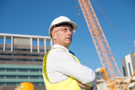 Confident construction engineer in hardhat with arms crossed on chestの写真素材