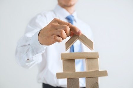 Close up of businessman building tower of wooden blocksの写真素材
