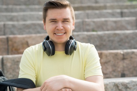 Urban young man with skateboard sitting on stair stepsの写真素材