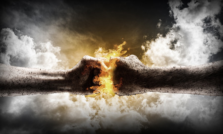 Close up of two fists hitting each other over dramatic sky backgroundの写真素材