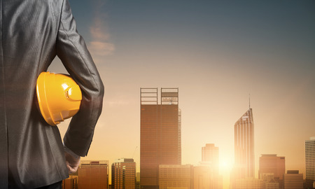 Close up of man in suit with construction helmet and gloves in handの写真素材