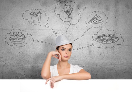 Portrait of pretty female holding blank white ad board and dreamingの写真素材