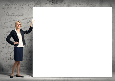 Fullbody of blond businesswoman with white blank bannerの写真素材