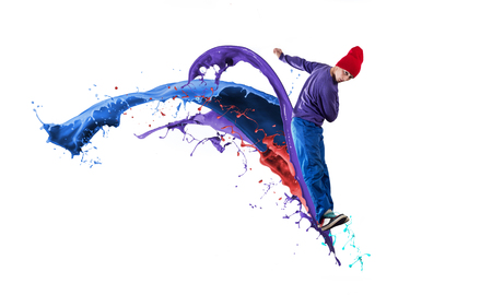 Young male dancer in jump on white background with colorful paint plashesの写真素材