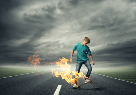 Skater boy riding on his skateboard burning in fireの写真素材