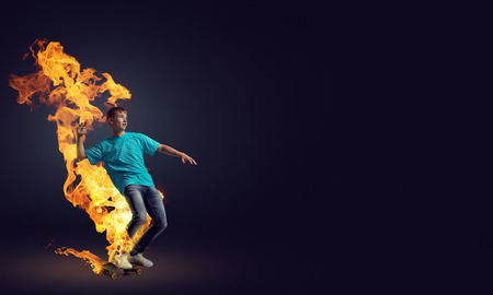 Skater boy riding on his skateboard burning in fireの写真素材