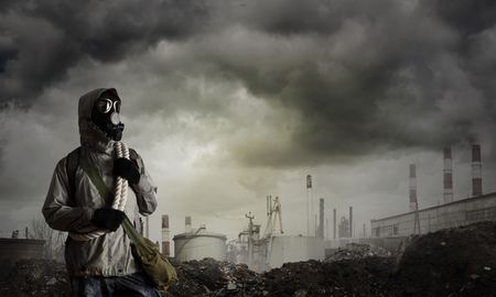 Man survivor in gas mask on industrial gray backgroundの写真素材