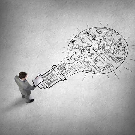 Top view of businessman with folder and plan sketches on floorの写真素材