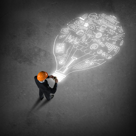 Top view of engineer man with coffee cup and business strategy sketches on floorの写真素材