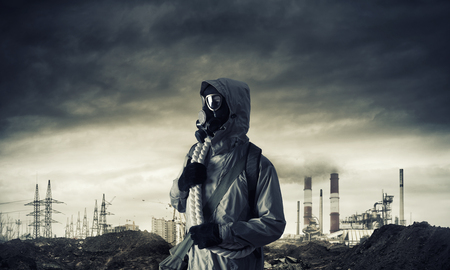Man survivor in gas mask on industrial gray backgroundの写真素材