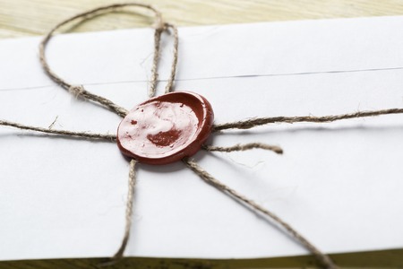 Old letter envelope with wax seal on wooden surfaceの写真素材