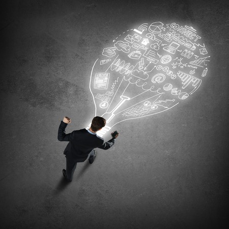 Top view of businessman with mobile phone looking at plan sketches on floorの写真素材